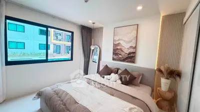Modern bedroom with stylish decor and large window in a contemporary apartment.