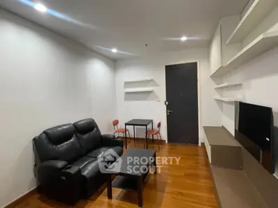 Modern living room with sleek furniture and wooden flooring in a cozy apartment.