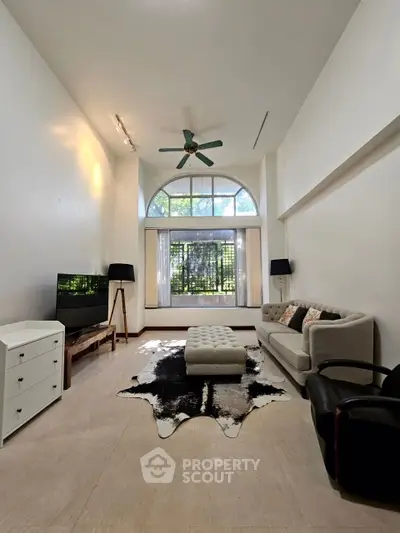 Spacious living room with modern decor and large window view.