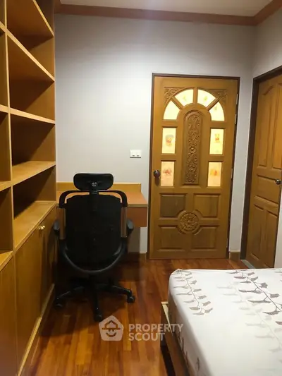 Cozy bedroom with wooden furniture and built-in shelves, perfect for a comfortable living space.