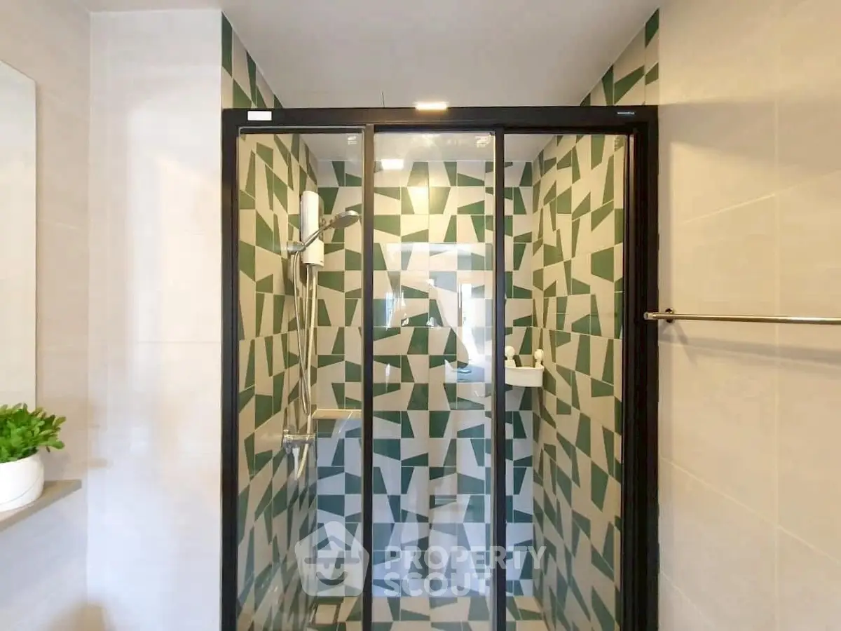 Modern bathroom with geometric tile shower and glass door