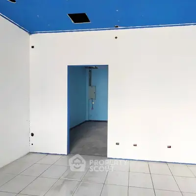 Spacious interior with white walls and blue ceiling, ideal for customization.