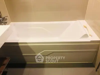 Modern bathroom with sleek bathtub and neutral tile design