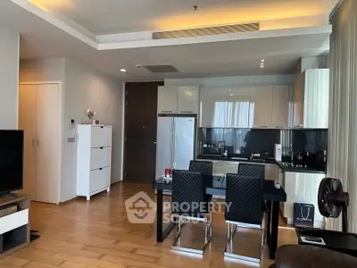 Modern open-layout kitchen with sleek appliances and dining area in stylish apartment.