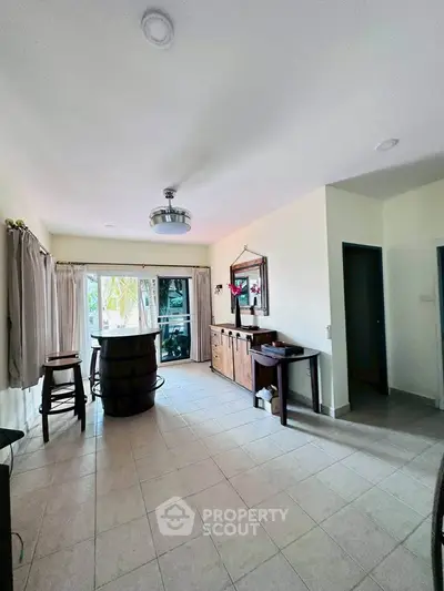 Spacious living room with modern decor and natural light, perfect for relaxation and entertainment.