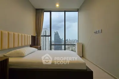 Modern bedroom with city skyline view through large windows, featuring minimalist design and neutral tones.