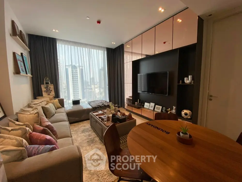 Modern living room with large windows and stylish decor in a high-rise apartment.