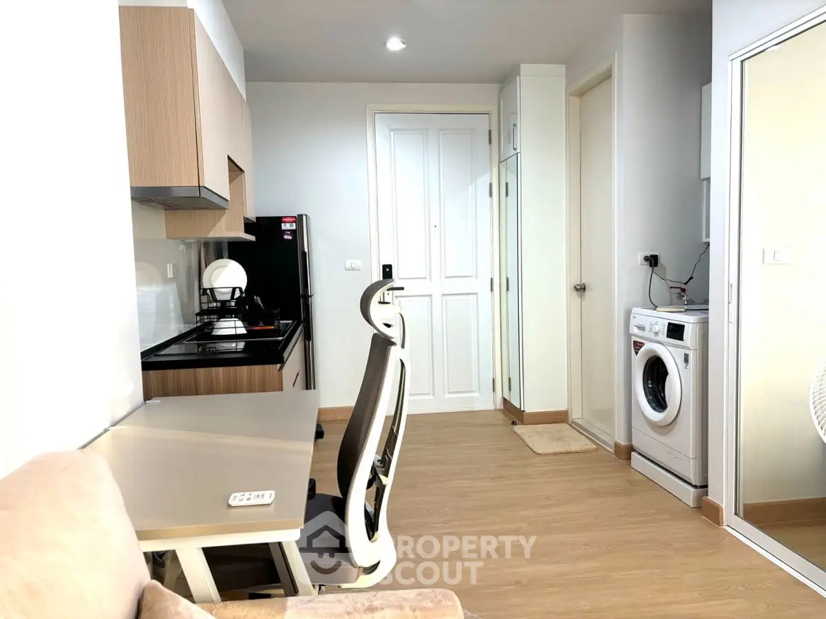 Modern apartment interior with kitchen and washing machine, featuring sleek design and efficient use of space.