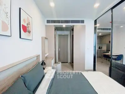 Modern bedroom with stylish decor and open view into kitchen area