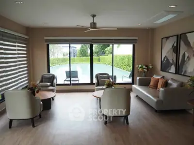 Spacious living room with pool view, modern furniture, and large windows for natural light.