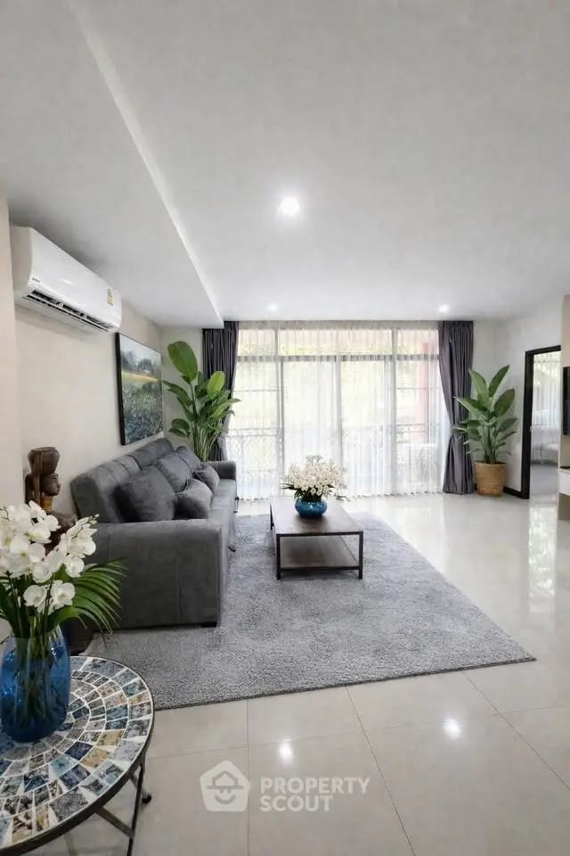 Spacious living room with modern decor and large windows for natural light.