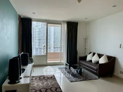 Modern living room with balcony view in urban apartment, featuring sleek furniture and natural light.