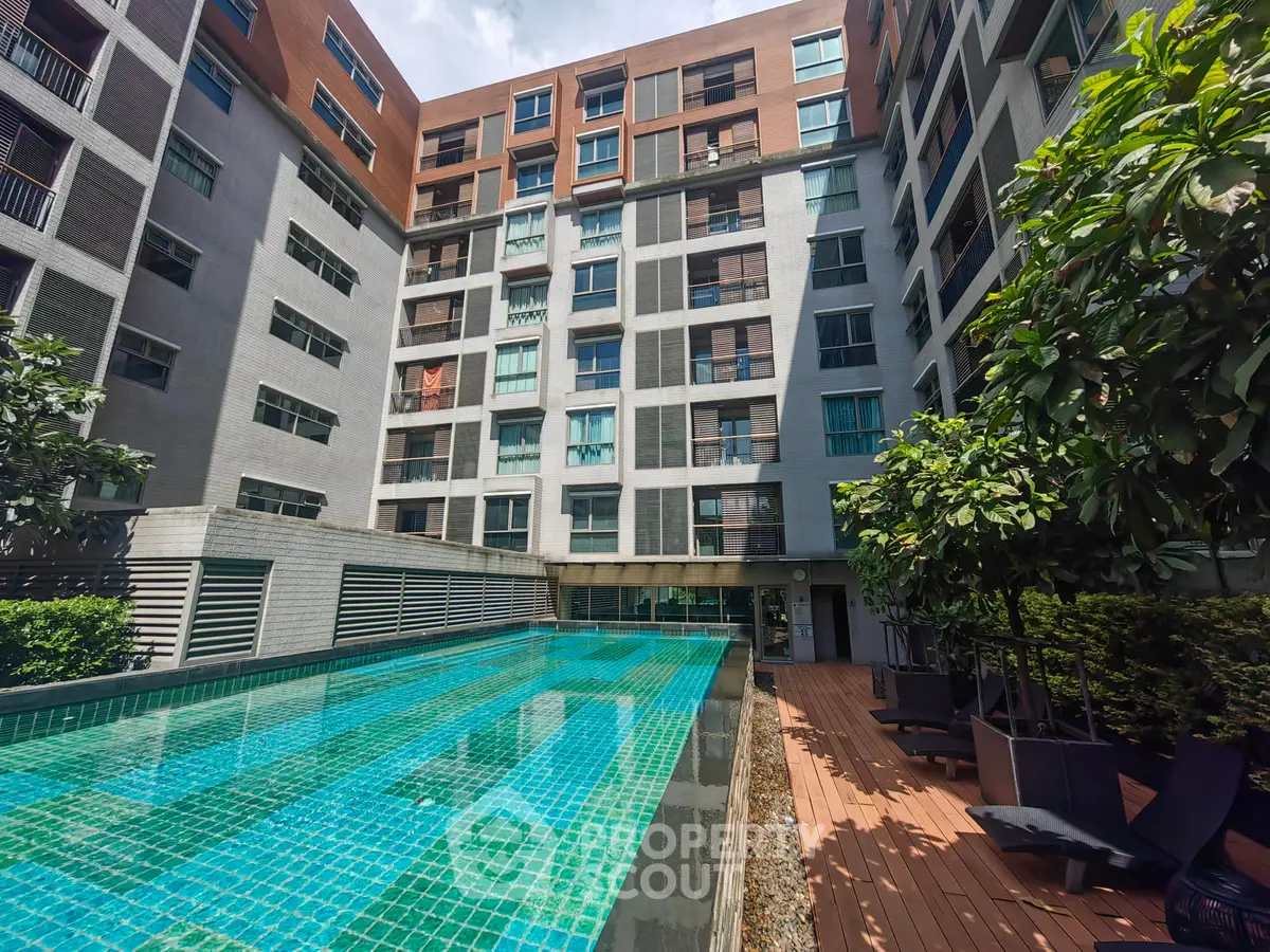 Modern apartment building with pool and lush greenery, perfect for urban living.
