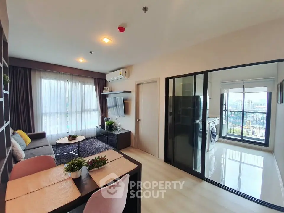 Modern living room with balcony and washing machine, featuring stylish decor and ample natural light.