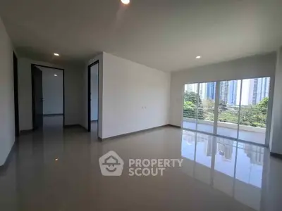 Spacious modern living room with large windows and city view, perfect for urban living.