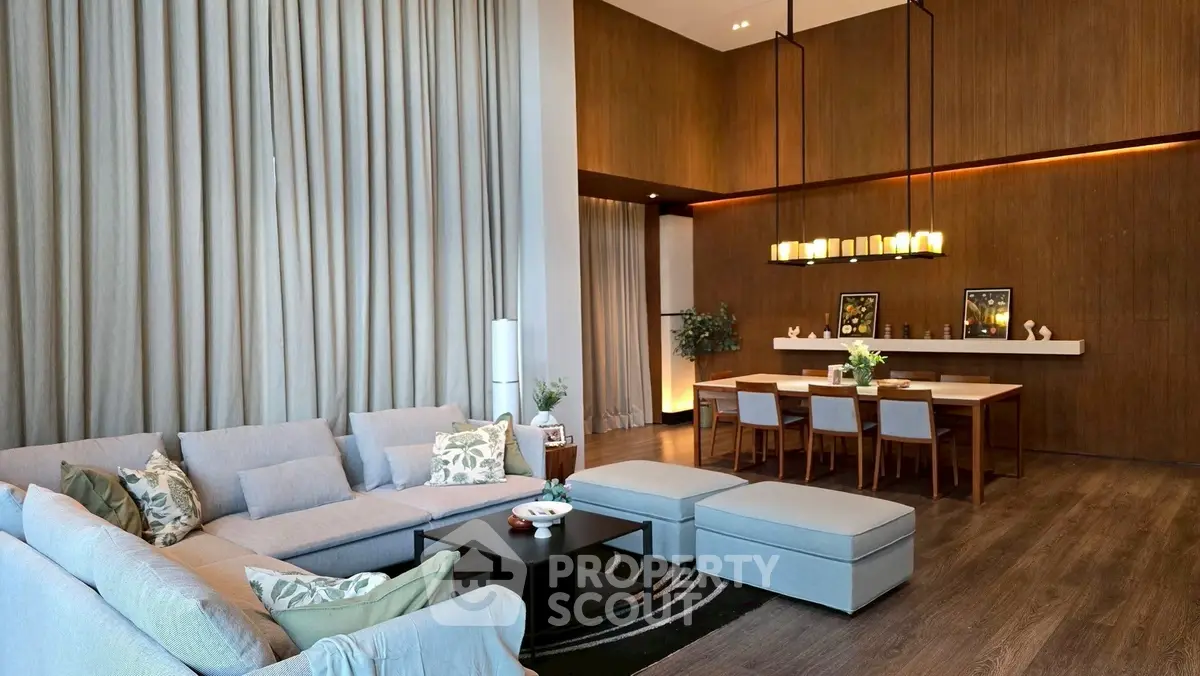 Luxurious open-plan living room with high ceilings and elegant dining area, perfect for entertaining.