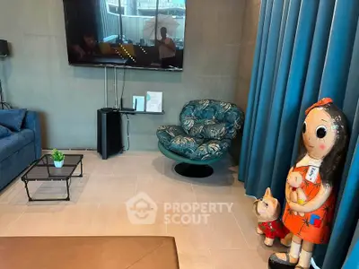 Stylish living room with modern decor and unique art pieces, featuring a plush chair and wall-mounted TV.