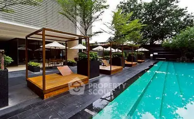 Luxurious outdoor pool area with stylish cabanas and lush greenery