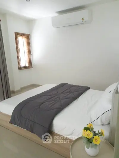 Cozy bedroom with modern air conditioning and natural light, perfect for relaxation.
