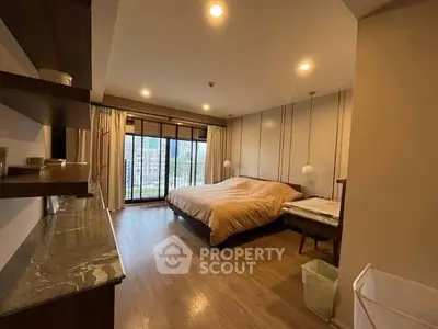 Spacious bedroom with large windows and modern decor, offering a cozy and inviting atmosphere.