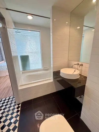 Modern bathroom with sleek design, featuring a bathtub and stylish sink, perfect for contemporary living.