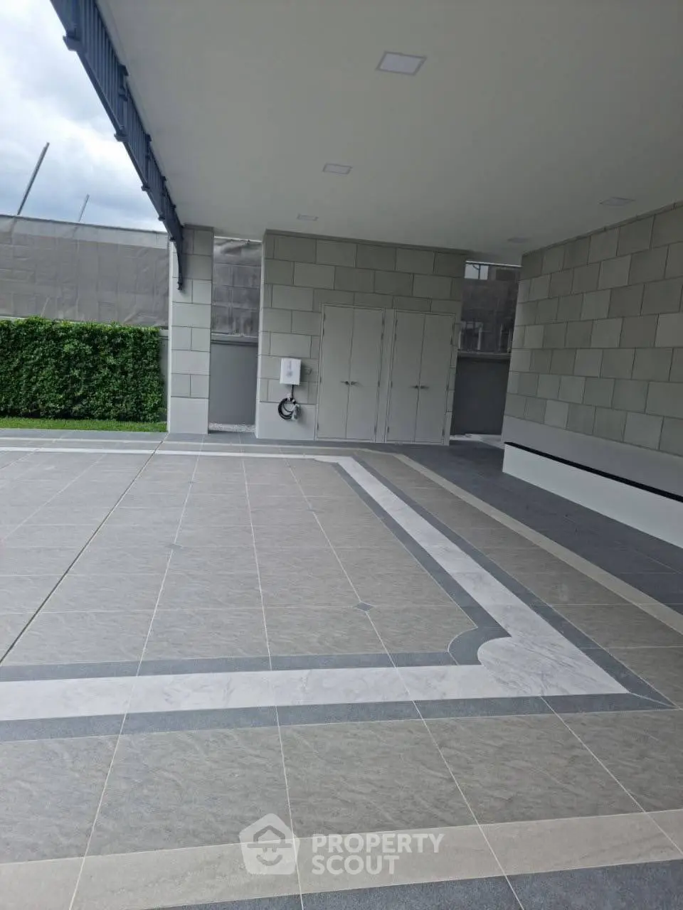 Modern building entrance with sleek tile flooring and greenery
