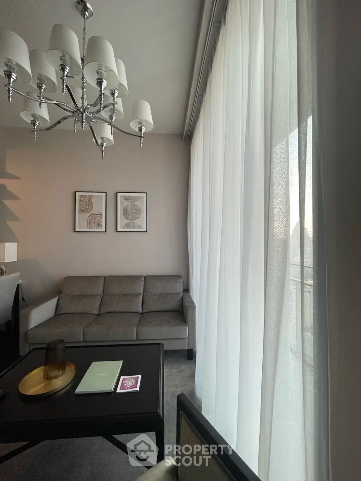 Elegant living room with modern chandelier and large window drapes