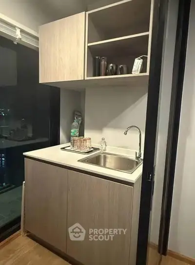 Compact kitchen with modern cabinetry and city view window