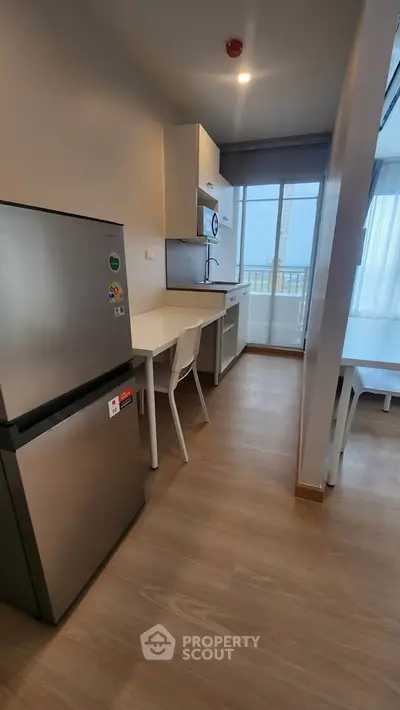 Modern kitchen with sleek appliances and open layout, featuring a large window for natural light.
