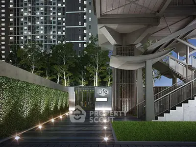 Modern building entrance with sleek design and lush greenery, perfect for urban living.