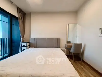 Modern bedroom with stylish furniture and balcony view in a contemporary apartment.