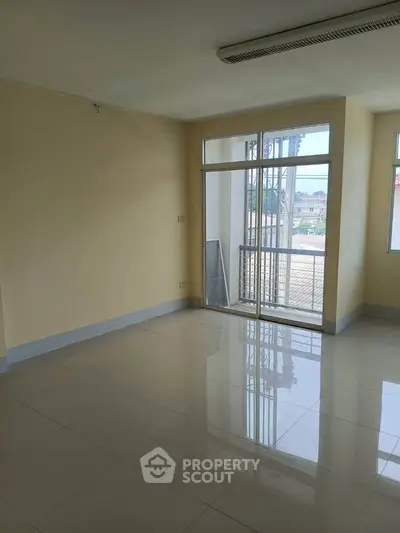 Spacious empty room with large windows and balcony access, perfect for customization.
