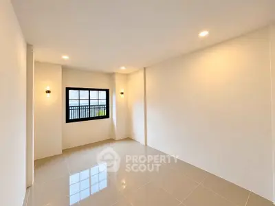 Spacious empty room with modern lighting and large window