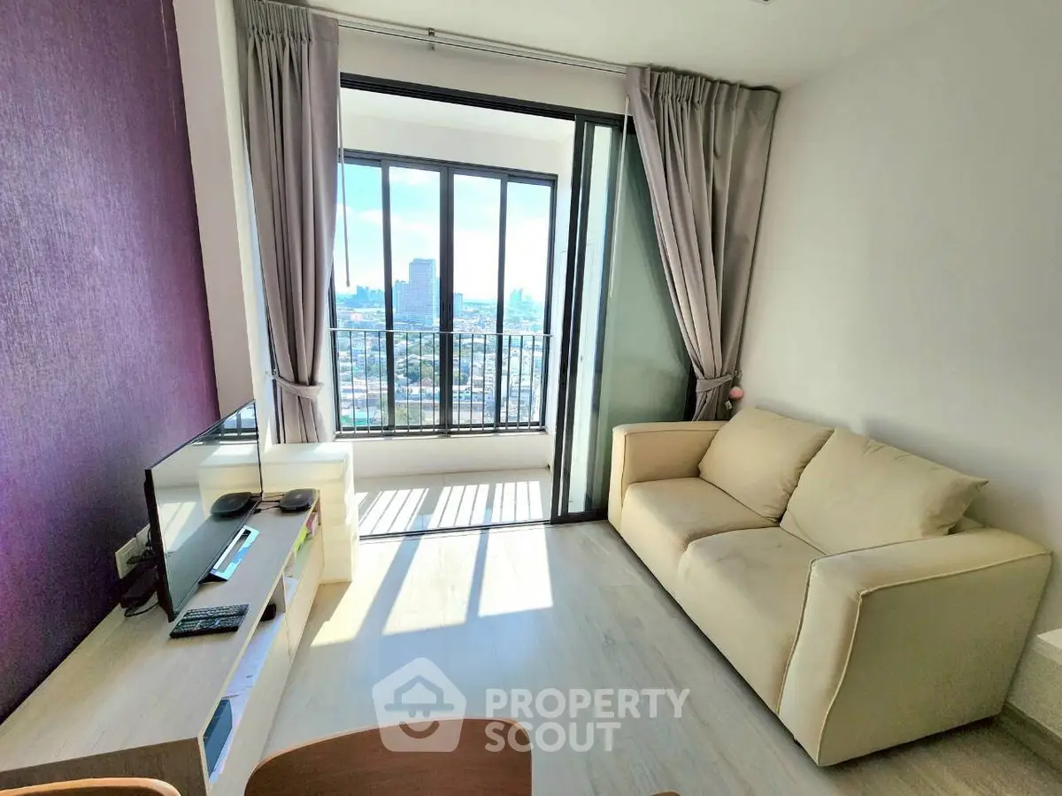Bright living room with balcony and city view, modern furniture and natural light.