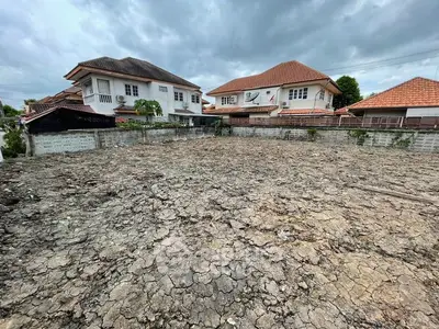 Vacant land plot surrounded by residential houses, ideal for new construction.