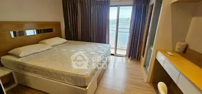 Spacious bedroom with modern furnishings and large window offering natural light.