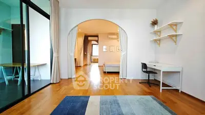 Spacious modern bedroom with wooden flooring and stylish decor