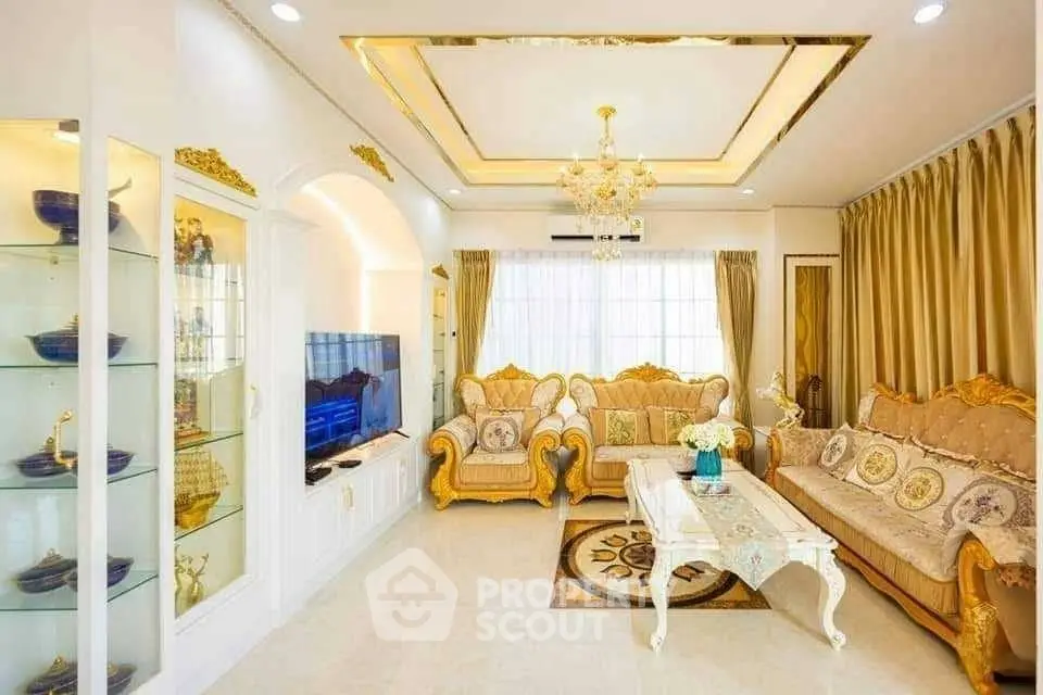 Luxurious living room with elegant gold accents and plush seating in a bright, spacious setting.