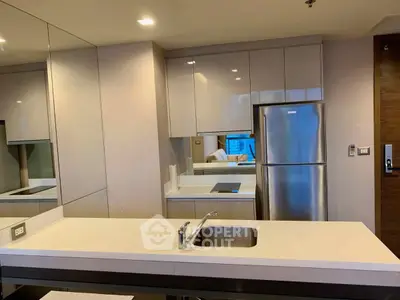 Modern kitchen with sleek cabinetry and stainless steel appliances in a stylish apartment.