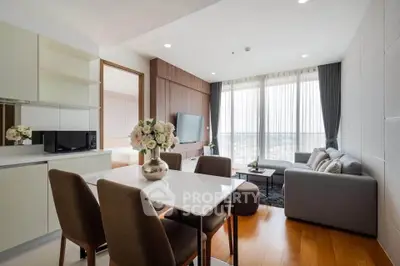 Modern living room with elegant dining area and large windows offering natural light.
