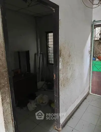 Unkempt interior room with peeling paint and cluttered floor, potential for renovation.