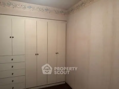 Cozy bedroom with built-in wardrobe and floral wallpaper border
