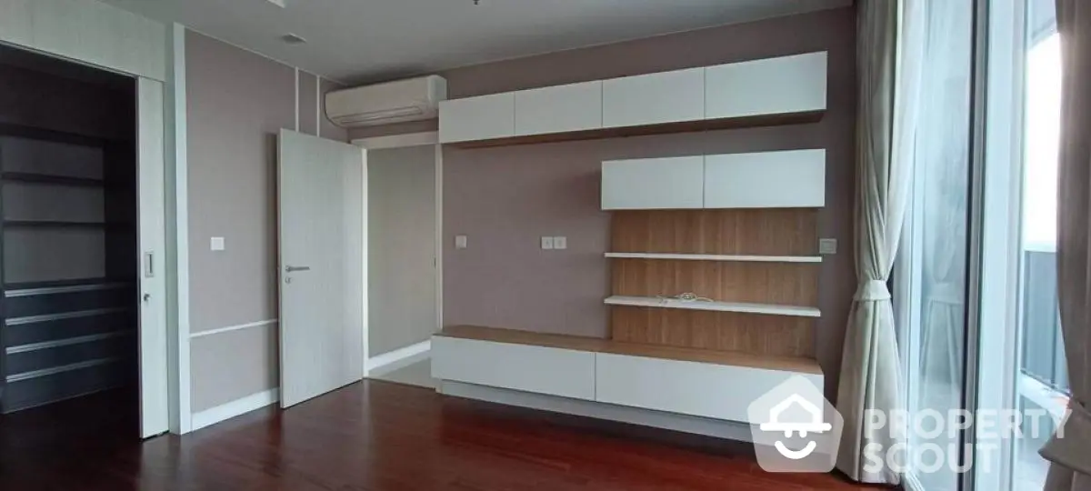 Spacious modern living room with built-in shelves and large windows