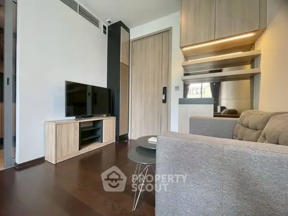 Modern living room with sleek furniture and wall-mounted TV in a stylish apartment.