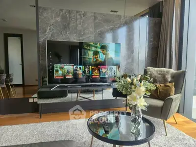 Luxurious living room with modern decor and large TV, perfect for entertainment.