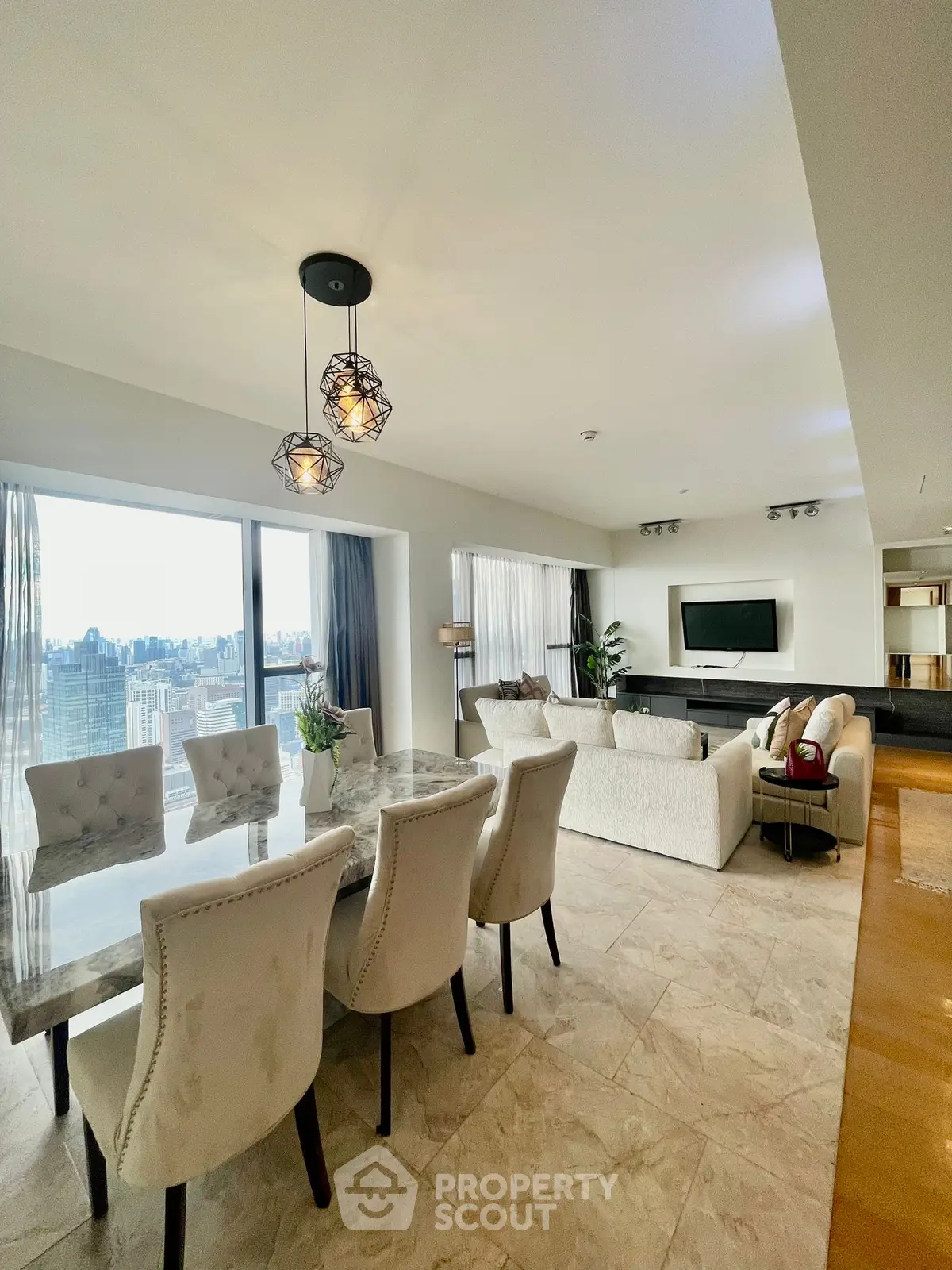 Luxurious open living room with elegant dining area and city view.