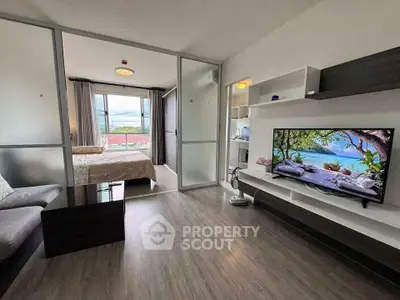 Modern living room with open layout and scenic view, featuring sleek furniture and a large TV.