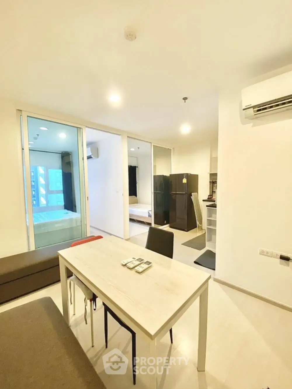 Modern open-plan living room with dining area and view into bedroom