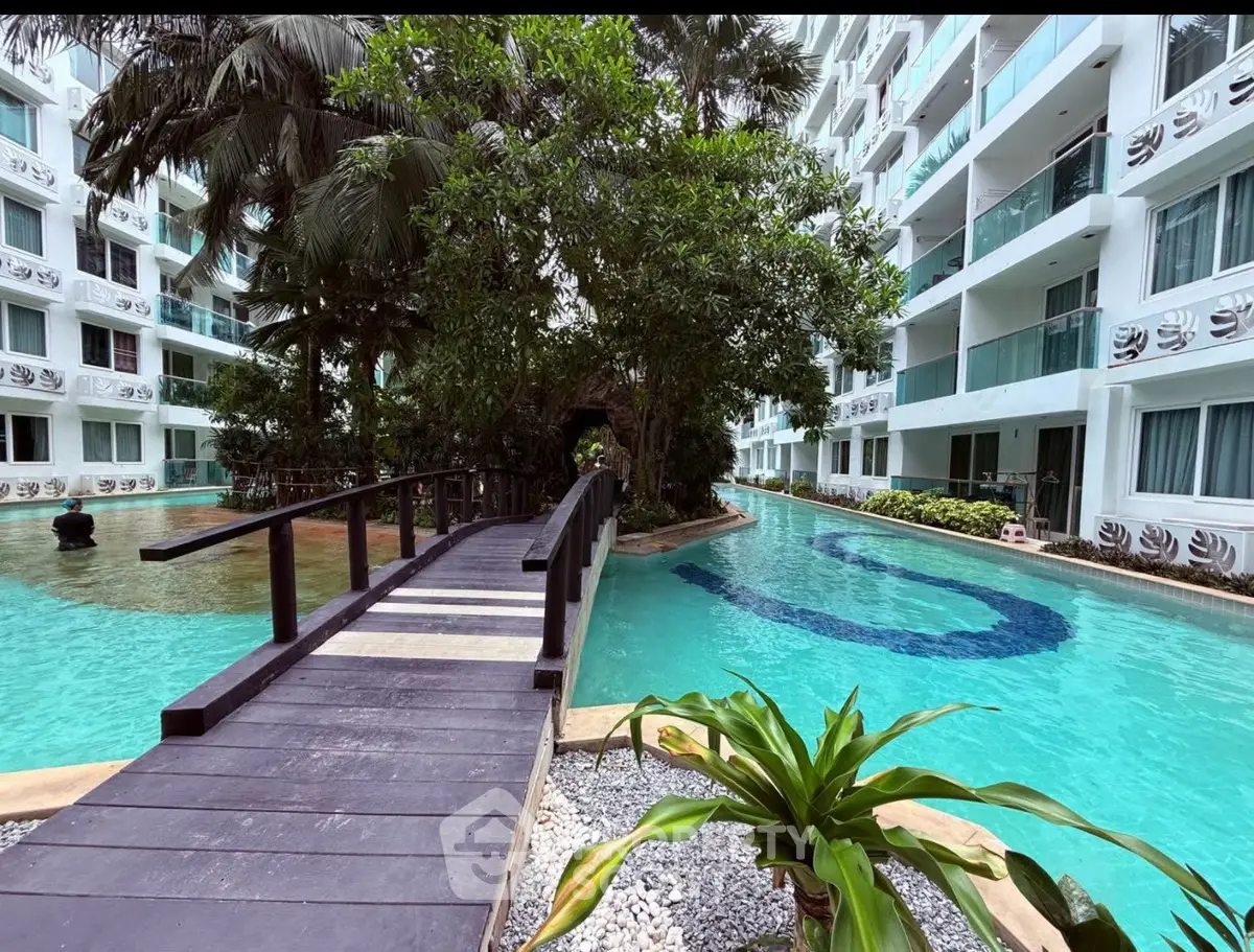 Luxurious condo with tropical pool and lush garden view, perfect for resort-style living.