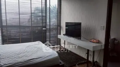 Modern bedroom with large windows and sleek TV setup